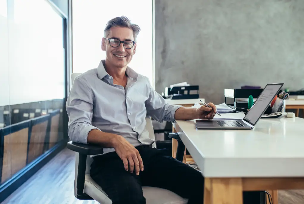 A man signing up for a business loan in an office.