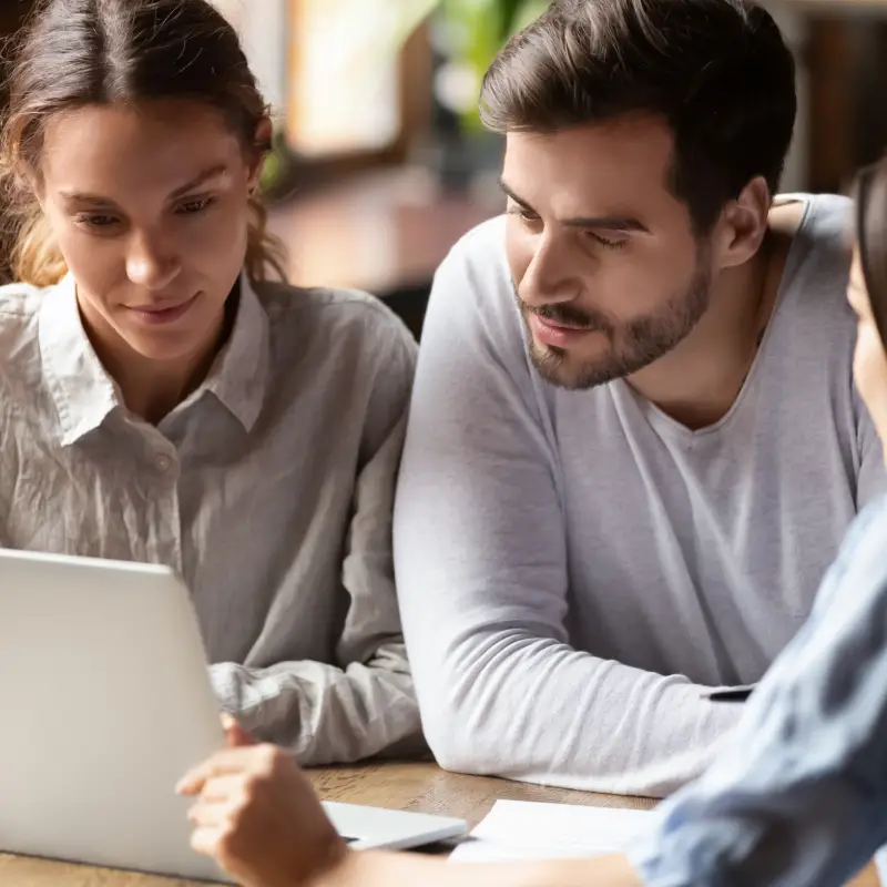 A couple discussing investment property options with a broker.