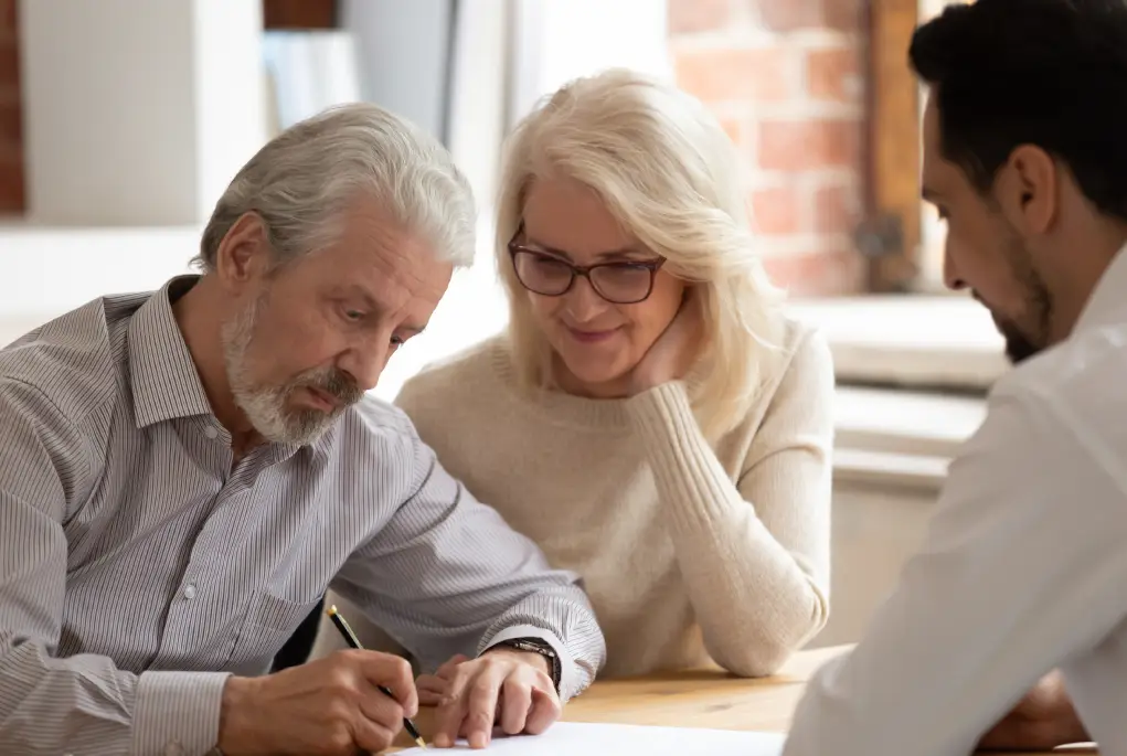 A couple signing papers after receiving investment property advice.