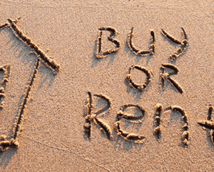 House outline and 'Buy or Rent?' in beach sand. A visual question about housing decisions, whether to buy property or choose renting.