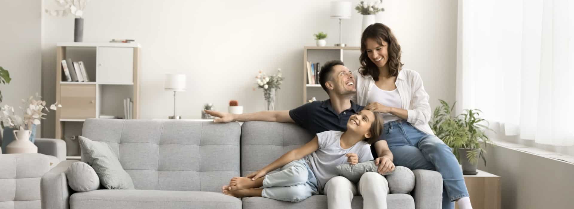 Happy family sitting on the couch after discovering the ways to pay of their mortgage quicker