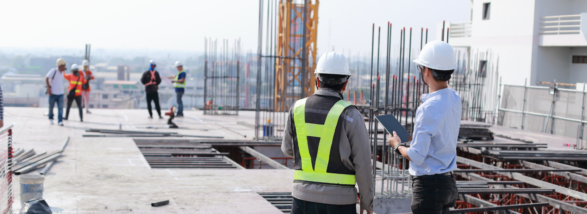 Construction workers and supervisors at building site with safety gear, representing commercial property development funded through commercial property and constructions loans 