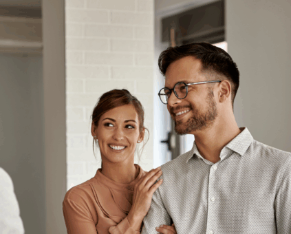 Couple shaking hands with loan officer while viewing an investment property