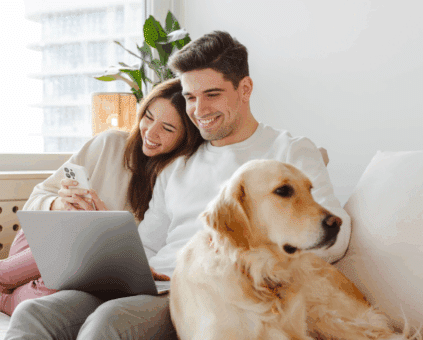 Couple with dog reviewing home loan pre-approval on laptop