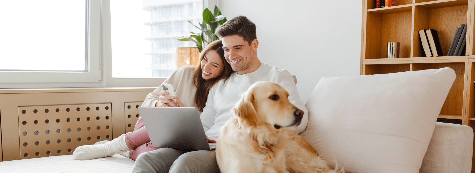 Couple with dog reviewing home loan pre-approval on laptop