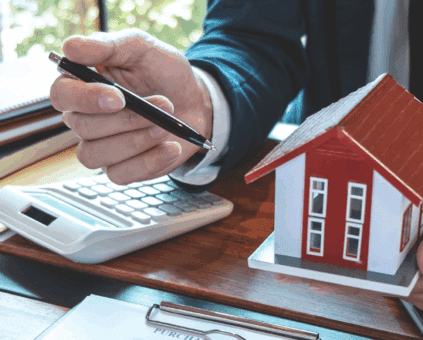 Mortgage broker calculating home loan refinancing savings with house model