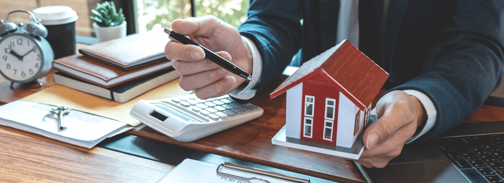 Mortgage broker calculating home loan refinancing savings with house model