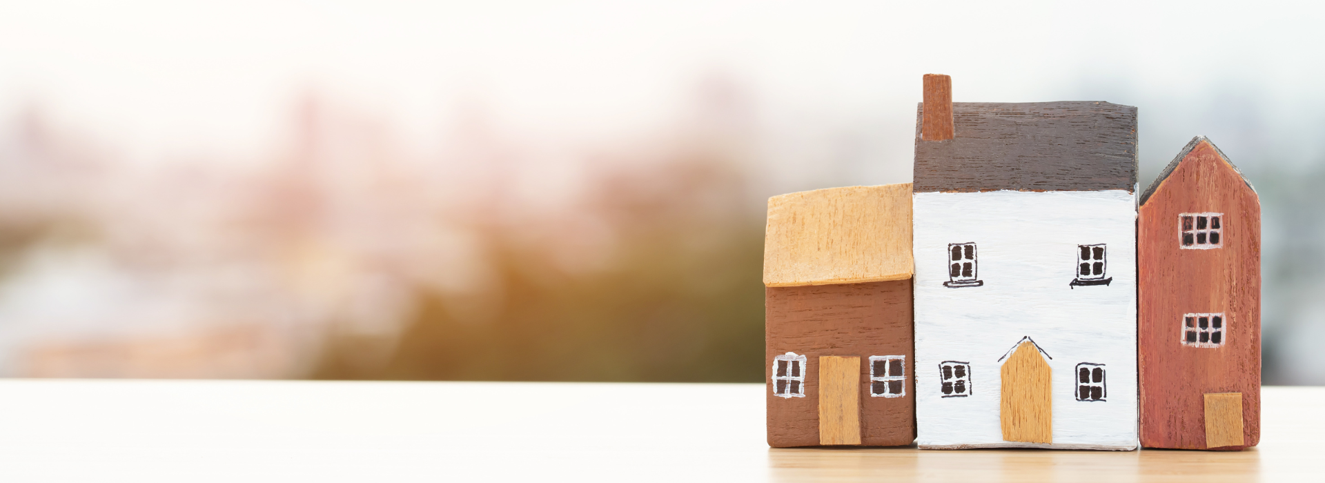 Wooden toy houses representing first home buyer property ownership and homeownership journey