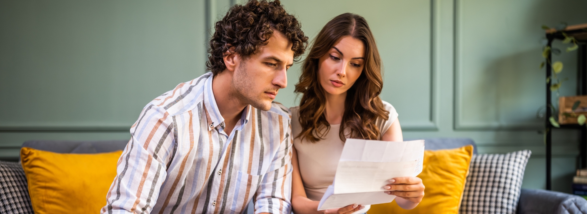Coast couple reviewing their home loan statement at a kitchen table with a Fox Home Loans broker