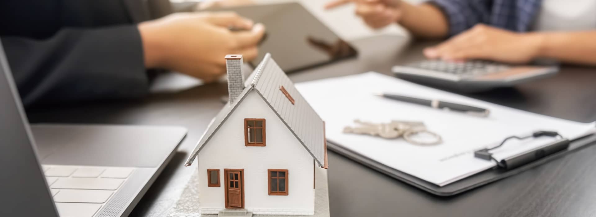 broker sitting with a customer at a table, comparing home loan options on an iPad.